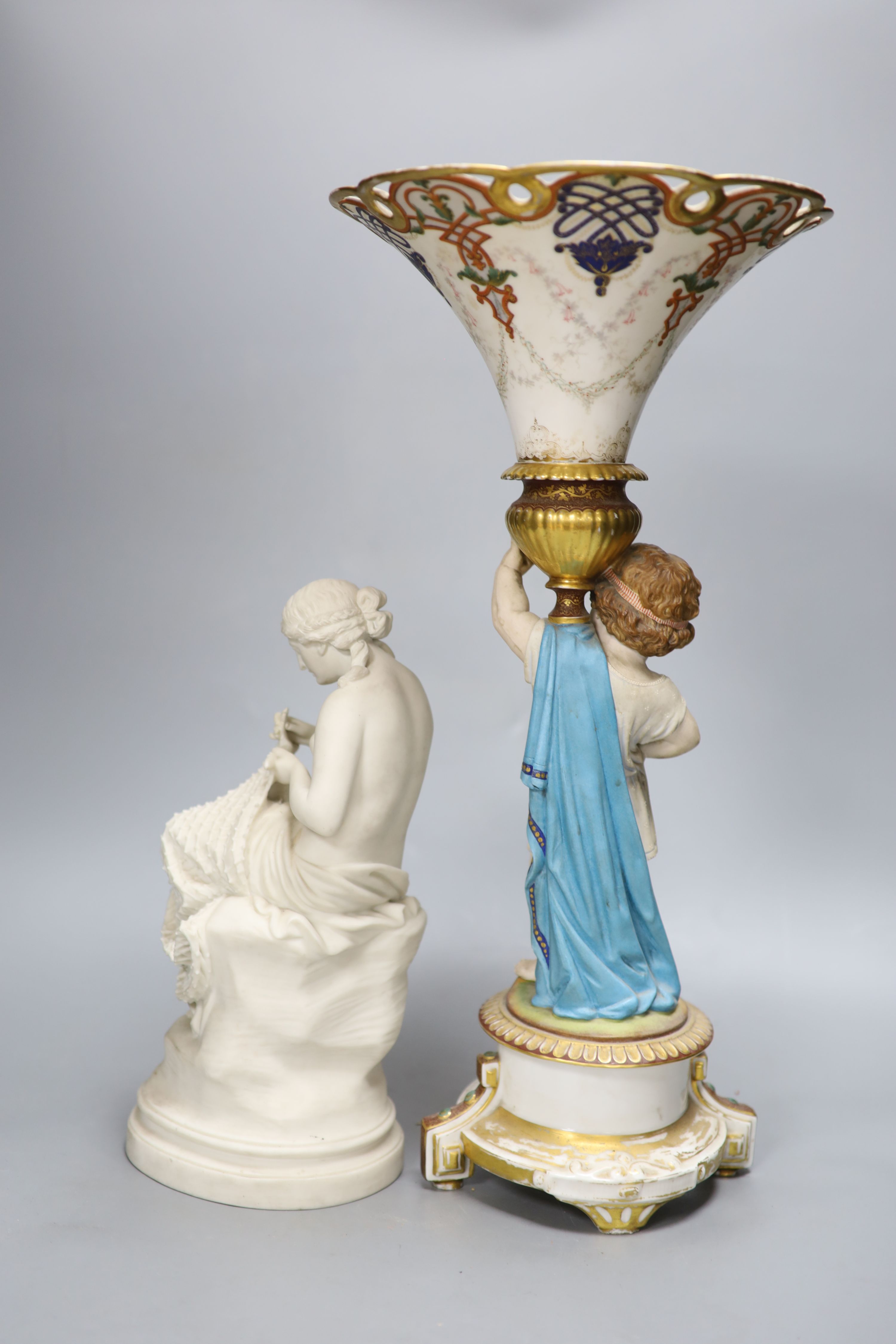 A Victorian Parian figure of a scantily clad fisher girl mending a net and a French trumpet shaped figural vase, tallest 49.5cm